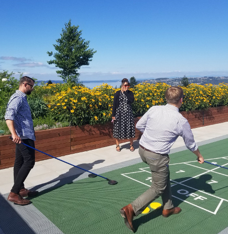 South Sound Property Tour: Proctor Station Members play shuffleboard on Proctor Station's rooftop deck